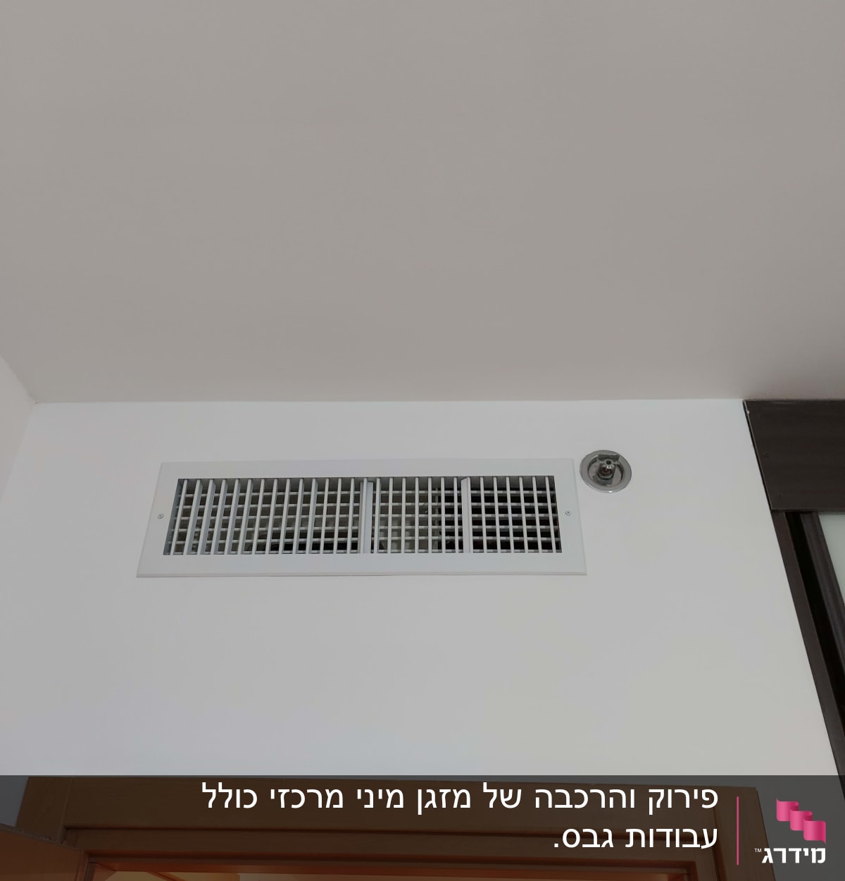 פתח אוורור של מזגן בתקרה לבנה